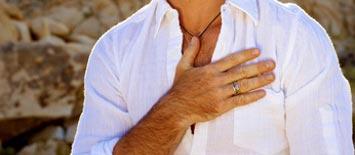 Mann mit weißem Hemd hält seine rechte Hand auf sein Herz.